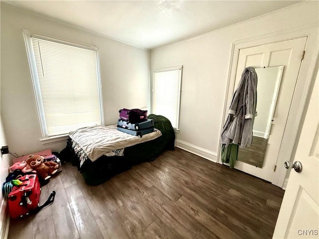 bedroom featuring dark wood-style floors, multiple windows, and baseboards