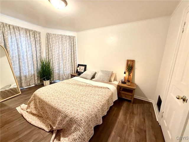 bedroom with baseboards, dark wood-type flooring, and crown molding