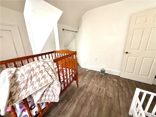 interior space with dark wood-style floors, baseboards, and vaulted ceiling