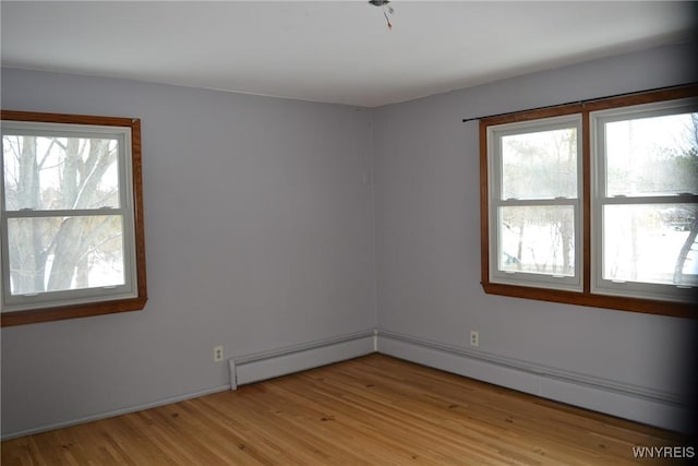 empty room with a baseboard heating unit, light wood-type flooring, and a baseboard radiator