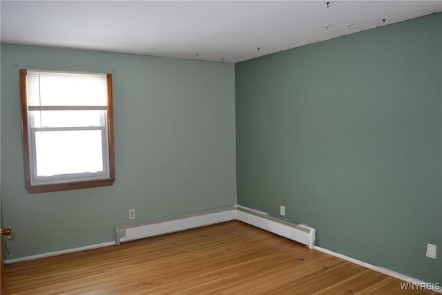 empty room with light wood-style floors and baseboard heating