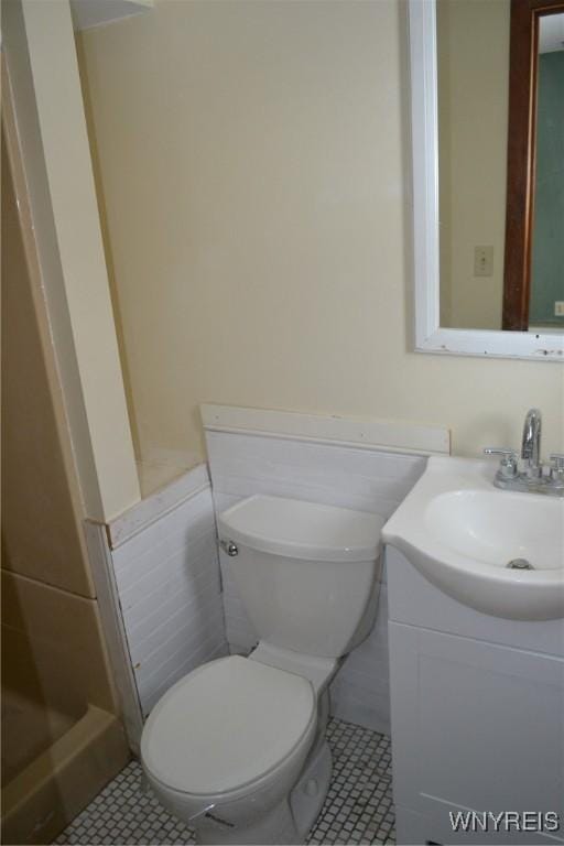 bathroom with toilet, tile patterned floors, and vanity