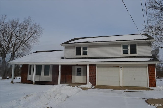 view of front of house featuring an attached garage, brick siding, and a porch