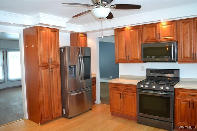 kitchen featuring light countertops, appliances with stainless steel finishes, ornamental molding, light wood finished floors, and brown cabinetry