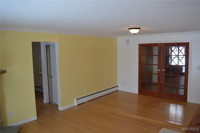 empty room featuring ornamental molding, french doors, baseboard heating, and light wood-type flooring