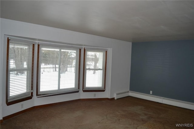 unfurnished room featuring dark colored carpet, baseboards, and baseboard heating