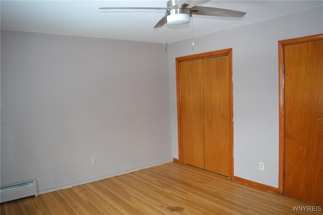 spare room with light wood-style floors, ceiling fan, a baseboard heating unit, and baseboards