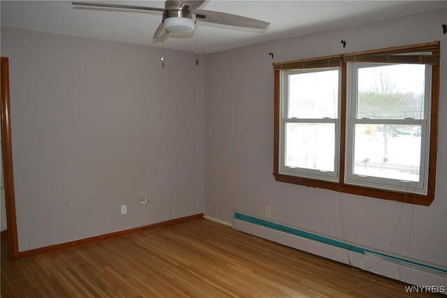 unfurnished room with light wood-style floors, a baseboard radiator, ceiling fan, and baseboards