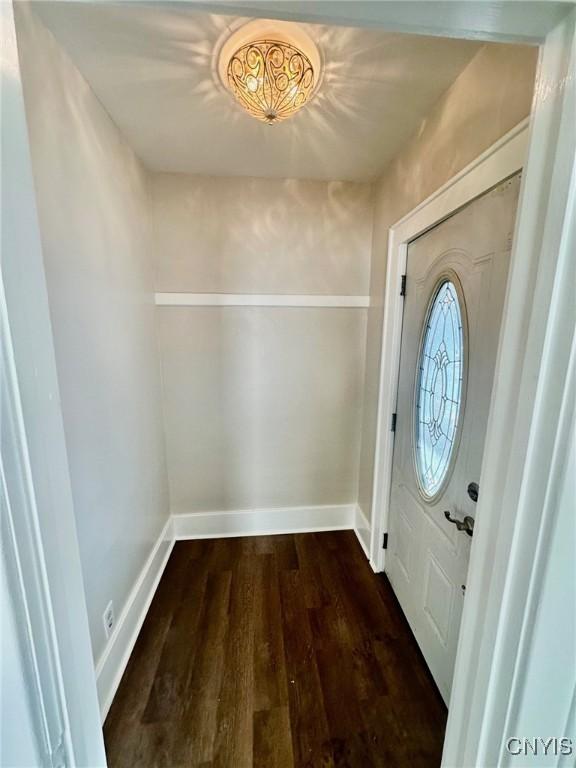 foyer with dark wood-type flooring and baseboards