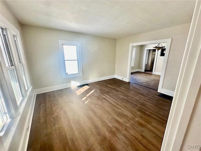 spare room with visible vents, dark wood finished floors, and baseboards