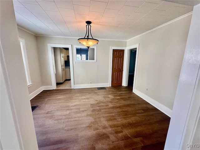 unfurnished dining area with baseboards, wood finished floors, visible vents, and crown molding