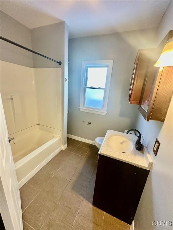 bathroom featuring tile patterned flooring, toilet, vanity, baseboards, and tub / shower combination