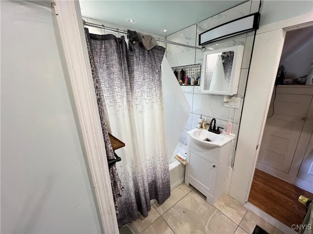 bathroom with a sink, decorative backsplash, and shower / bath combo with shower curtain