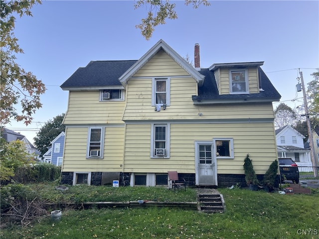 back of property featuring roof with shingles, a chimney, and a yard