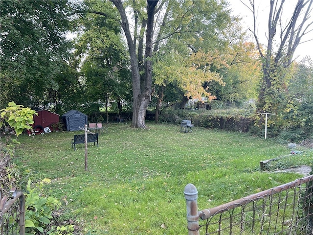 view of yard with an outbuilding, fence, and a storage shed