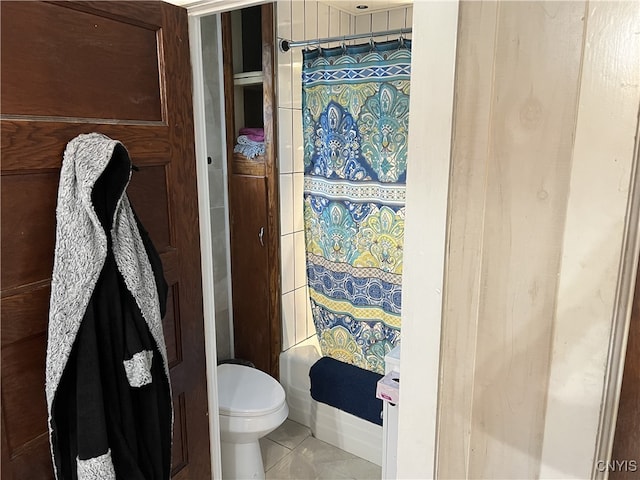 bathroom with tile patterned flooring, shower / tub combo with curtain, and toilet