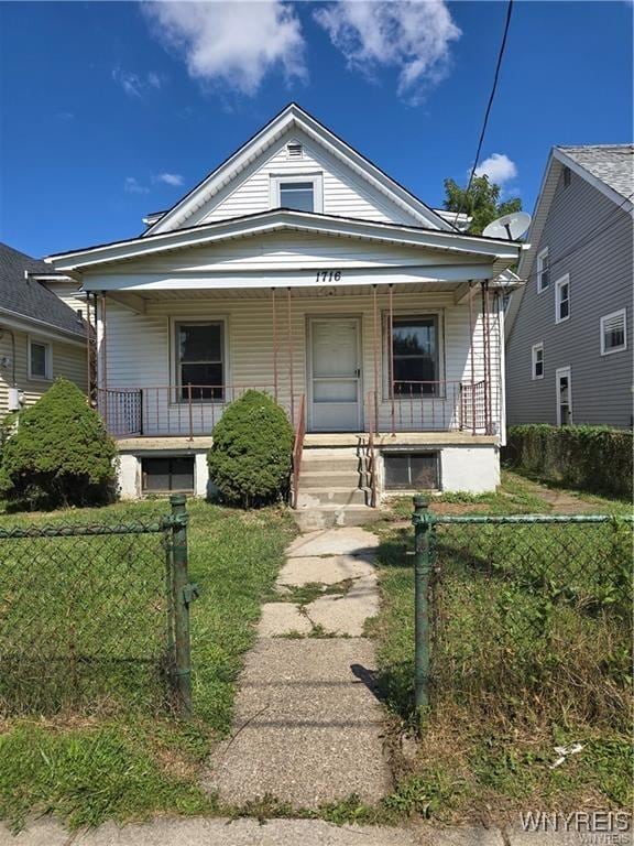 view of front of house with a porch, a fenced front yard, and a front yard