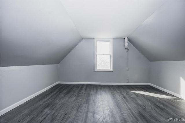 bonus room featuring vaulted ceiling, baseboards, and dark wood finished floors