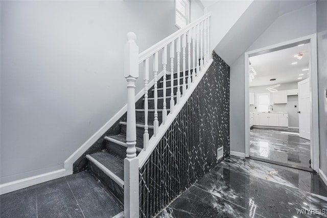 stairs featuring marble finish floor and baseboards