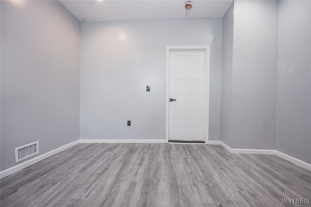 empty room with baseboards, visible vents, and light wood-style floors