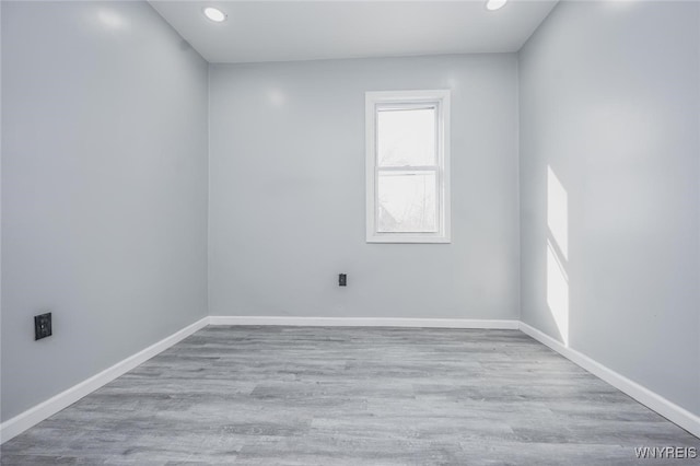 empty room with recessed lighting, light wood-type flooring, and baseboards