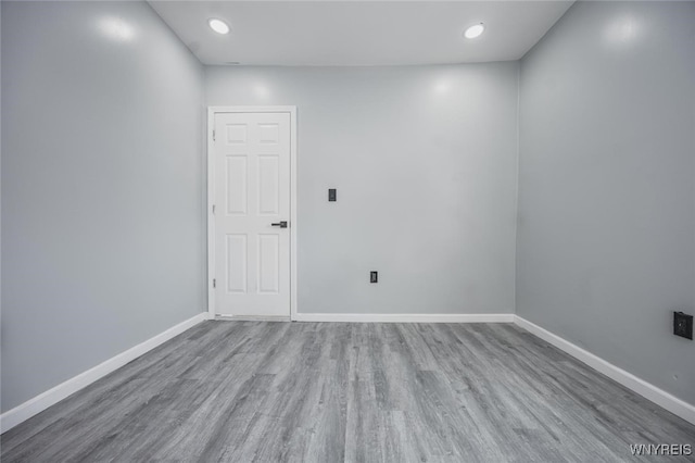 unfurnished room featuring light wood finished floors, baseboards, and recessed lighting