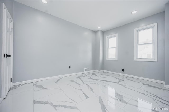 empty room with marble finish floor, recessed lighting, visible vents, and baseboards