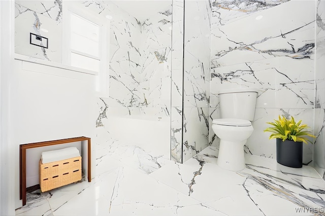 full bath featuring a shower, marble finish floor, toilet, and stone wall