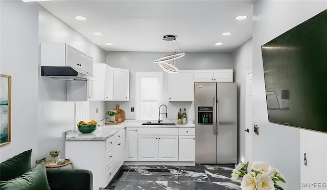 kitchen featuring white cabinets, a sink, hanging light fixtures, and stainless steel fridge with ice dispenser