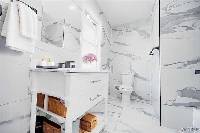 full bath featuring stone wall, toilet, vanity, marble finish floor, and a marble finish shower