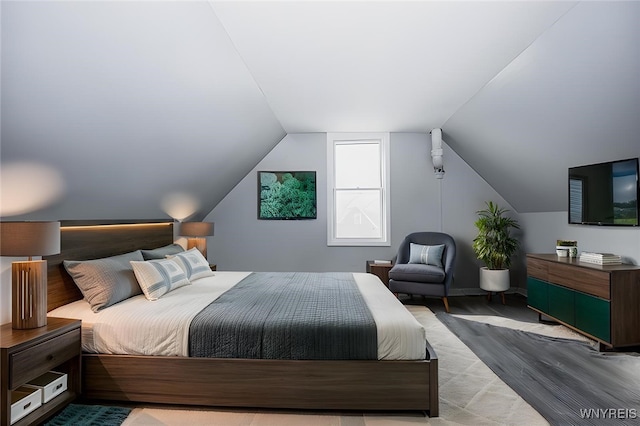 bedroom with vaulted ceiling and wood finished floors