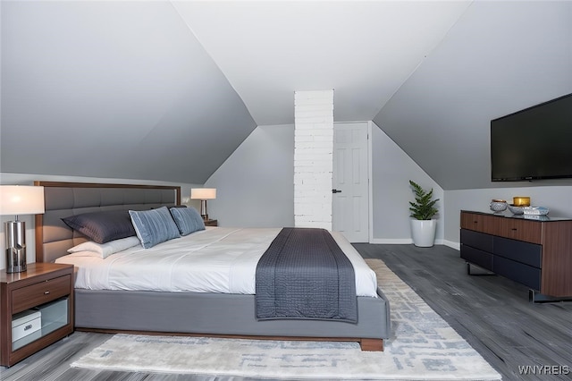 bedroom featuring lofted ceiling, dark wood-type flooring, and baseboards