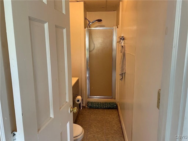 bathroom featuring toilet, a shower stall, vanity, and tile patterned floors