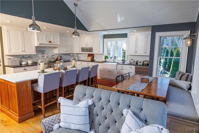 kitchen with dark countertops, white cabinetry, and pendant lighting