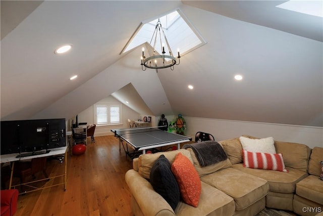 rec room with vaulted ceiling with skylight, dark wood-style flooring, recessed lighting, and an inviting chandelier