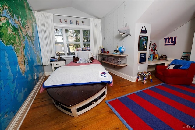 bedroom with lofted ceiling, baseboards, and wood finished floors