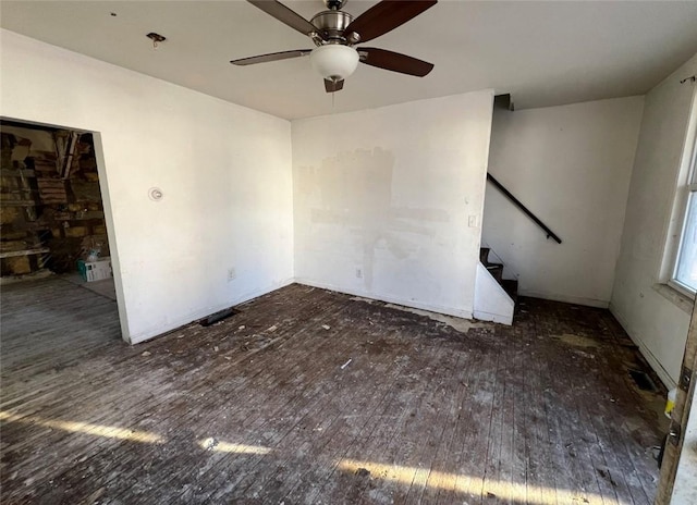 interior space with ceiling fan, stairway, and dark wood-type flooring