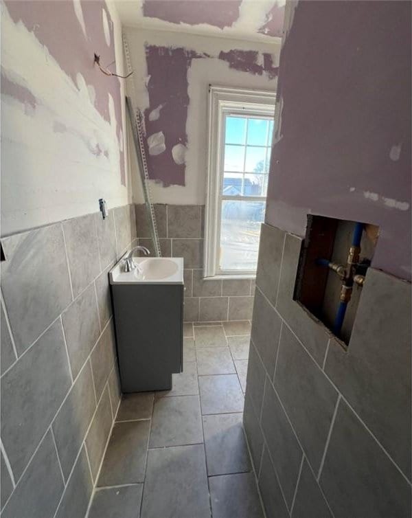 bathroom featuring wainscoting, tile walls, vanity, and tile patterned floors