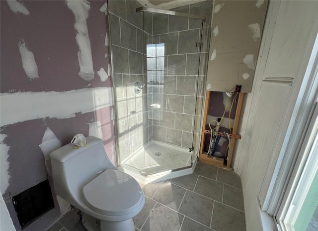 full bathroom with toilet, a stall shower, and tile patterned flooring