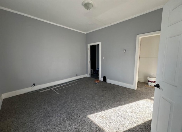 carpeted spare room with crown molding and baseboards