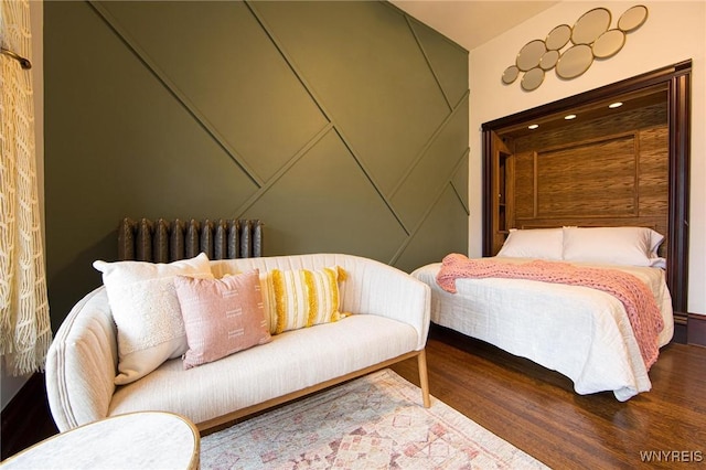 bedroom featuring radiator and wood finished floors