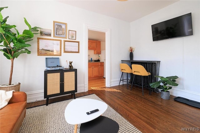 living area featuring baseboards and wood finished floors