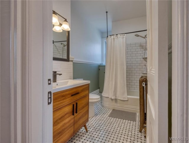 bathroom featuring tile walls, toilet, shower / bath combo, vanity, and tile patterned flooring