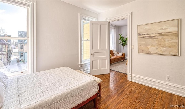 bedroom with multiple windows, baseboards, and dark wood-style flooring