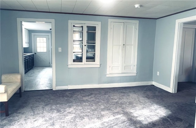 unfurnished bedroom with ornamental molding, carpet, and baseboards