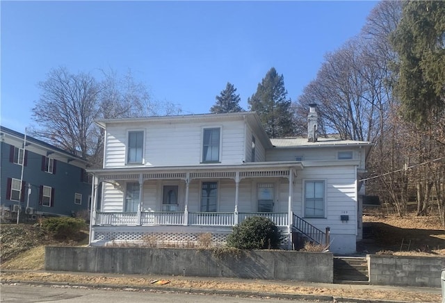 view of front of house featuring covered porch and a chimney