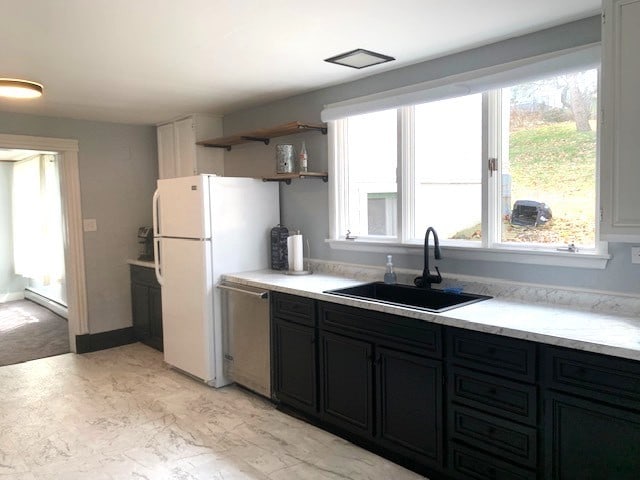 kitchen with a sink, open shelves, dishwasher, a baseboard heating unit, and dark cabinets