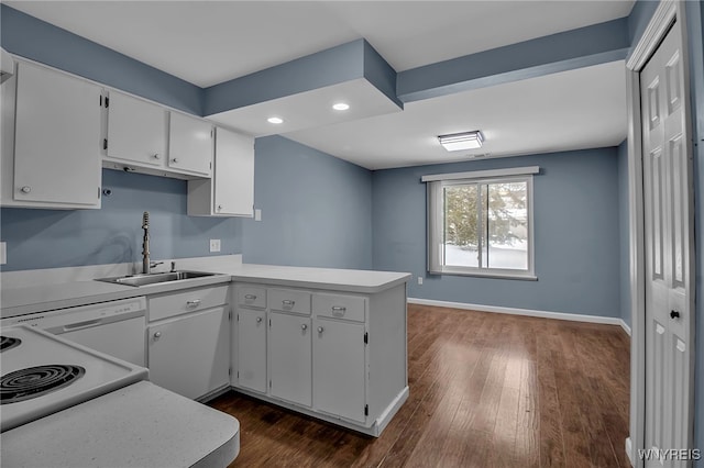 kitchen featuring light countertops, white cabinetry, a sink, white dishwasher, and a peninsula