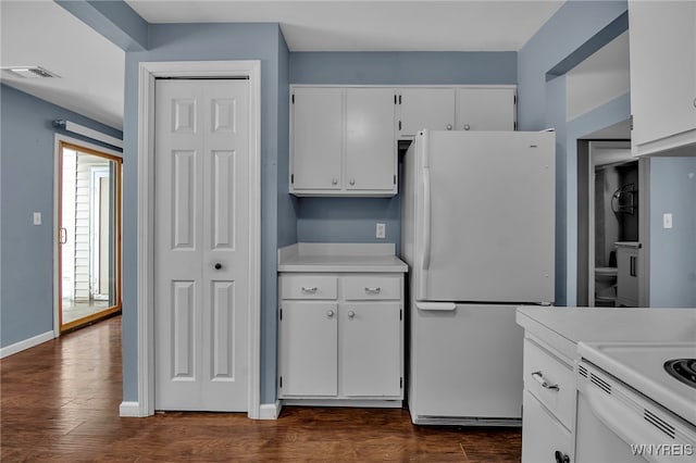 kitchen with light countertops, freestanding refrigerator, white cabinetry, and dark wood-type flooring