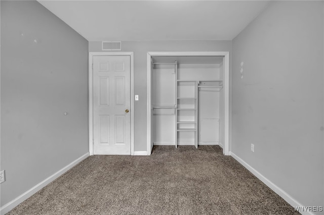 unfurnished bedroom with a closet, carpet flooring, visible vents, and baseboards